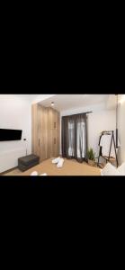a bedroom with a bed and a room with a tv at Pnoe Home Tinos in Tinos