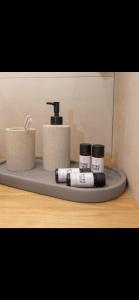 a bathroom shelf with a sink and toiletries on it at Pnoe Home Tinos in Tinos