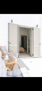 a room with a table and chairs and a mirror at Pnoe Home Tinos in Tinos +1 photo