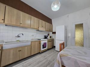 una cucina con mobili in legno e un frigorifero bianco di La Casa de Ely a Sant Carles de la Ràpita