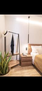 a bedroom with a bed and a table with a plant at Pnoe Home Tinos in Tinos