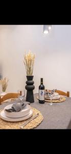 a table with a bottle of wine and glasses on it at Pnoe Home Tinos in Tinos