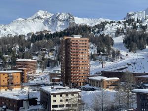 una ciudad con edificios y una montaña cubierta de nieve en Studio 2 personnes proche pistes avec balcon - Animaux admis - FR-1-351-48, en La Plagne