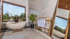 baño con bañera grande y ventana en Suka Villa Ubud, en Ubud