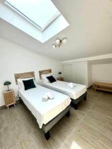 Dos camas en una habitación con tragaluz. en Duplex en résidence, en Propriano