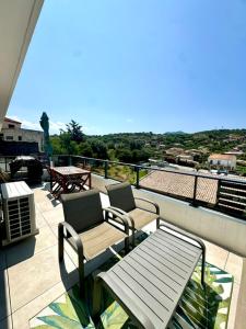 Un balcón con dos sillas y una mesa. en Duplex en résidence, en Propriano