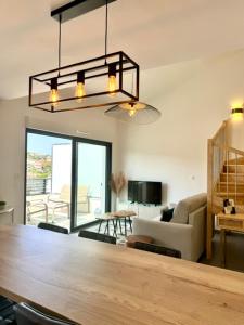 una sala de estar con una gran mesa de madera y un sofá en Duplex en résidence, en Propriano