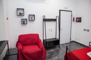 a red chair in a room with a mirror at 3 Rooms Catania - Vulcano bright independent studio apartment in Catania +5 photos