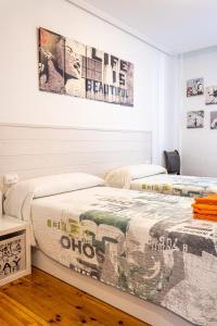 Dos camas una al lado de la otra en un dormitorio. en Apartamento Saioa, en Pamplona