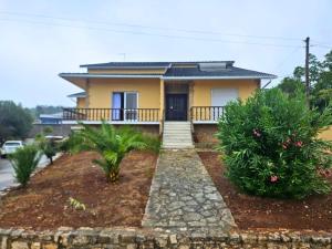 a yellow house with a balcony and some plants at Cozy rooms in Minde, Fatima in Minde