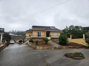a yellow house with a car parked in a parking lot at Cozy rooms in Minde, Fatima in Minde +5 photos