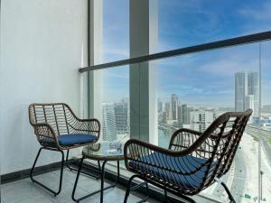 two chairs and a table on a balcony with a view at Stylish 1-Bedroom-Sleeps 4- Apartment -Bayz by Danube, Business Bay-29 in Dubai