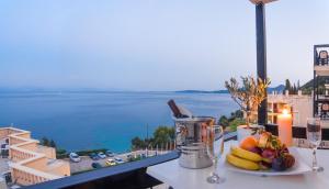 a plate of fruit on a table with a view of the ocean at Belvedere Hotel in Benitses