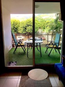 Una vista de un patio con una mesa y sillas. en K A Z - Les flamboyants, en Saint-Denis