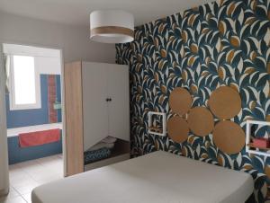 Habitación con cama y pared estampada en K A Z - Les flamboyants, en Saint-Denis