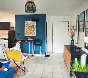 sala de estar con paredes azules, mesa y sillas en K A Z - Les flamboyants, en Saint-Denis