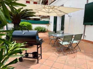 a grill and a table with chairs and an umbrella at Casa Baglio Monti in Palermo