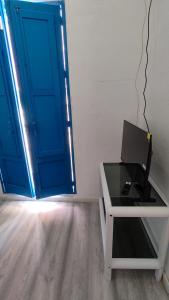 a laptop sitting on a desk in front of a blue door at Larimar in Almería