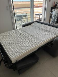 a hospital bed in a room with a window at T2 500m de la plage Clim wifi parking privé in Leucate-Plage