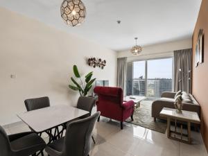 un salon avec un canapé, une table et des chaises dans l'établissement Contemporary and Spacious 1-Bedroom in AG tower - Business Bay, à Dubaï