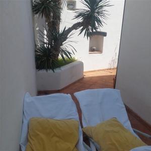a bed with two pillows in a room with palm trees at Apartment Arte by in Pješčana Uvala