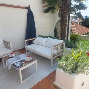 a patio with a white couch and a table at Apartment Arte by in Pješčana Uvala