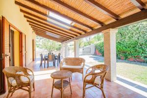 a patio with chairs and a table on a porch at Villetta Is Carcuris in Cardedu