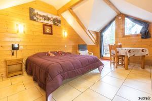a bedroom with a bed and a table in a room at Hôtel Résidence La Maison par Les Pins Sylvestres Amnéville in Amnéville