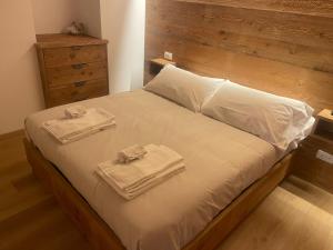 a bedroom with a bed with two towels on it at Appartamento Valsorda in Ponte di Legno
