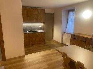 a kitchen with a table and a sink and a counter at Appartamento Valsorda in Ponte di Legno