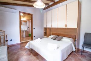 a bedroom with a white bed and a chair at Villetta Is Carcuris in Cardedu +24 photos