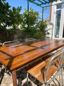a wooden table and chairs on a patio at Apartments Goldie in Senj +15 photos