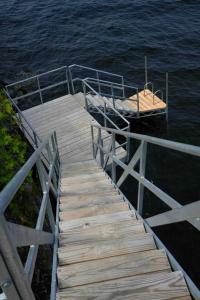 un molo in legno con una barca sull'acqua di Tradstuga modern lakefront tree cottage with sauna a North Hero
