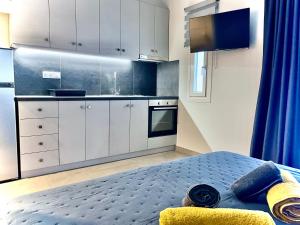 a kitchen with white cabinets and a bed in a room at Villa Maria Petru in Ierissos
