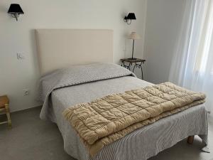 una camera da letto con un letto con una coperta sopra di Maison dans un hameau avec piscine a Gordes