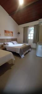 a bedroom with two beds and a window at Pousada Canto das Aguas in Serra do Cipo +46 photos