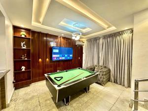 a living room with a pool table and a tv at Stay Well Homes Comfortinn in Lekki