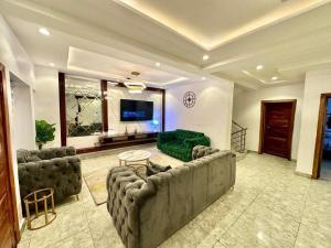 a large living room with a couch and a tv at Stay Well Homes Comfortinn in Lekki +9 photos