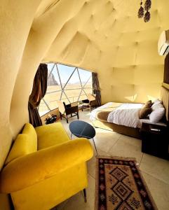een slaapkamer met een bed, een bank en een raam bij Wadi Rum Legend Luxury Camp in Wadi Rum +37 foto's