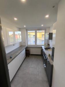 a large kitchen with white cabinets and a large window at apartament przy cukierni in Knurów +34 photos