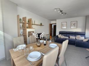 a dining room with a table and a blue couch at Km115 CREDENCIAL in Sarria