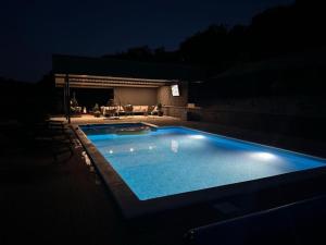 a swimming pool lit up at night at Apartman Zara in Krapina