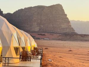 een groep tenten in de woestijn met een berg bij Wadi Rum Legend Luxury Camp in Wadi Rum