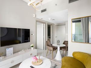 Una sala de estar con un televisor y una mesa. en Zada Tower Elegance - Premium 1BR in Business Bay-23, en Dubái