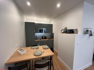 a kitchen with a wooden table in a room at Gaïa - Maison intra-muros 3 chambres in Avignon