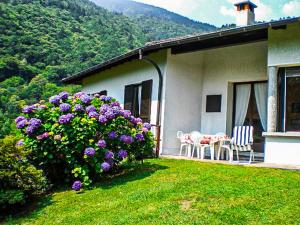 a house with purple flowers and a table and chairs at Villa Giuliana in Cannobio