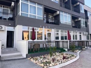 a building with a garden in front of it at LA PLAYA - Camere pe plaja cu sezlong gratuit in Eforie Nord