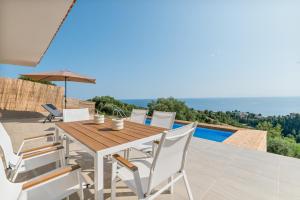a wooden table and chairs on the patio of a house at Blue and Green infinity in Agia Paraskevi