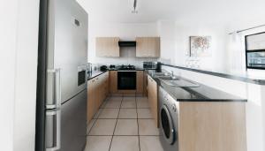 a kitchen with a refrigerator and a dishwasher at Opulent Heights- Westpoint Sandton in Johannesburg +23 photos