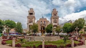 a large building with a fountain in front of it at Hotel Virgen del Carmen - Huaraz in Huaraz